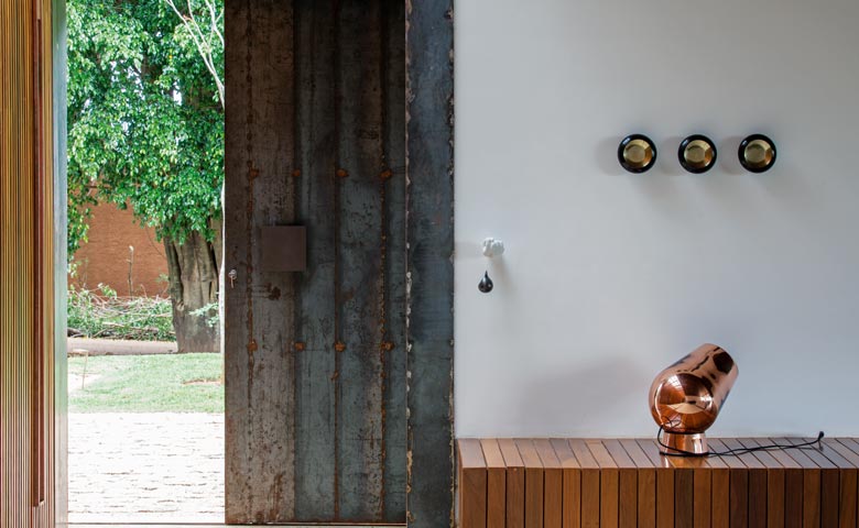 No interior paulista, projeto da Jacobsen Arquitetura, levemente suspenso do terreno, explora a madeira de brilho amazônico que faz a cabeça – e recobre as pranchetas – dos articuladores da nova casa brasileira